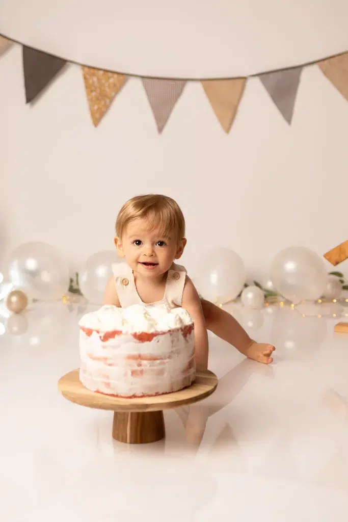 Bébé devant son gâteau lors d'une séance Smash the Cake avec décor anniversaire personnalisé en studio photo Essonne